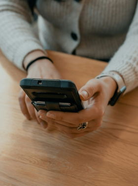 woman-in-white-sweater-holding-black-smartphone.jpg woman in white sweater holding black smartphone